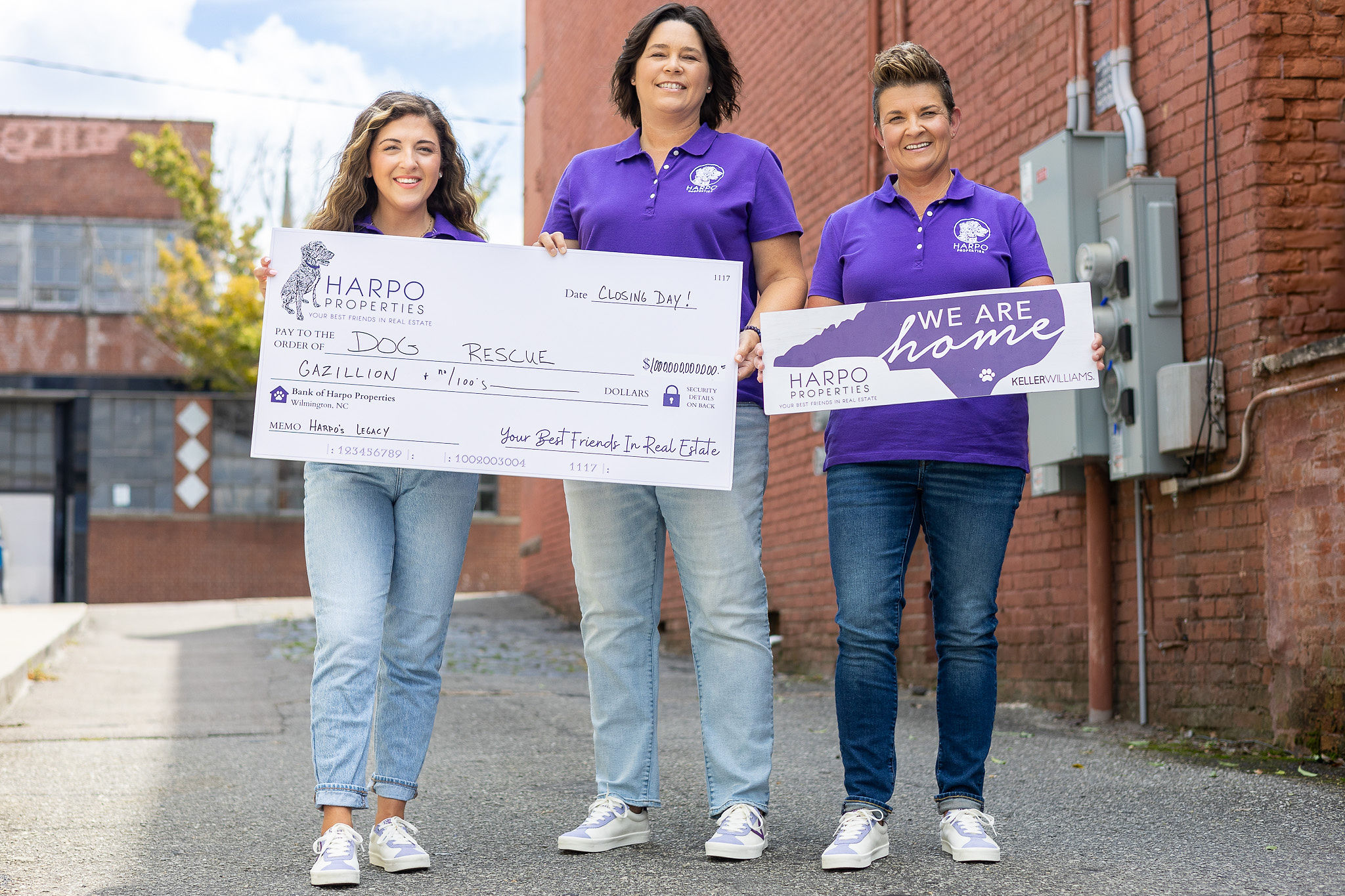 Harpo Properties' Melissa Martin, Charity Tuttle, and Morgan Grady holding large fake check to Dog Rescue